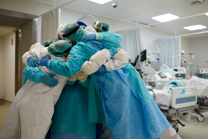 Healthcare workers hug and cuddle together at ICU
