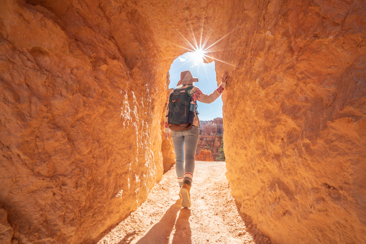 Young woman travels Bryce Canyon national park in Utah, United States, people travel explore nature. Girl hiking in red rock formations